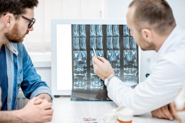 doctor explaining to patient how scoliosis can develop after spinal cord injury