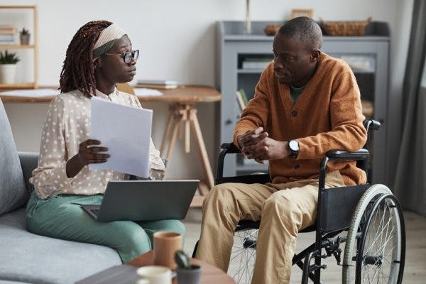 spinal stroke survivor sitting with caregiver learning more about the rare condition