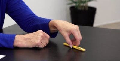 Therapeut zeigt Handübungen für Schlaganfallpatienten