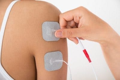 thérapeute appliquant une stimulation électrique à un patient victime d'un AVC massif