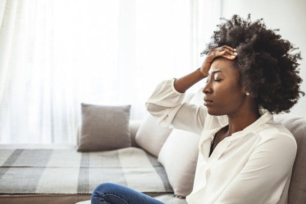 woman looking stressed out with hand on forehead