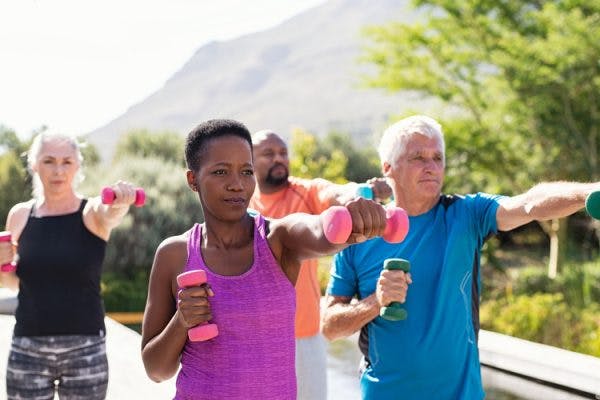 stroke patients exercising in the park using light weight dumbbells
