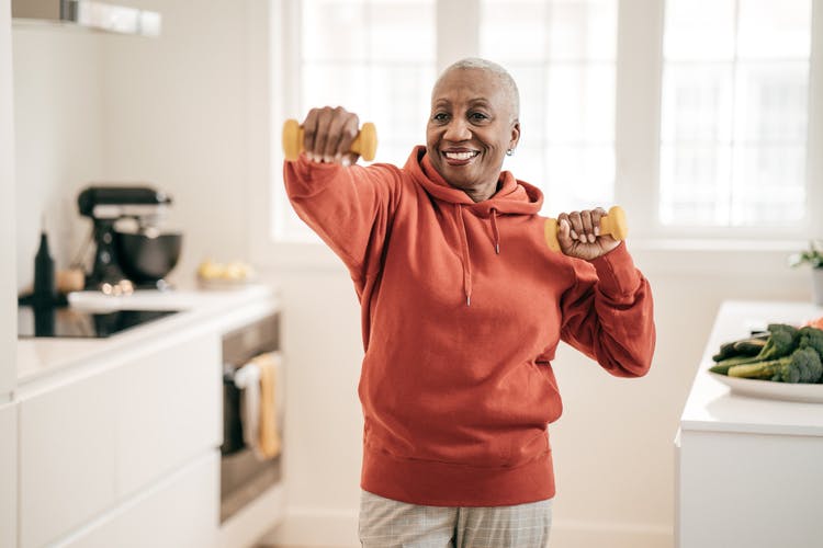 Stroke patient with dumbbells exercising at home with simple equipment