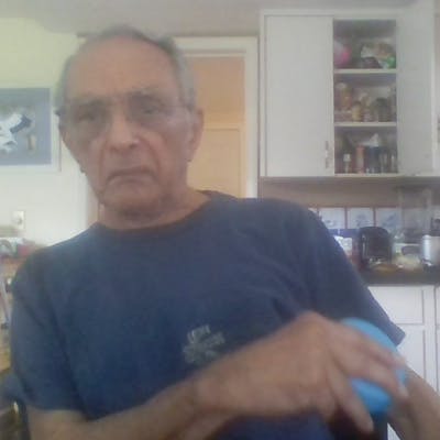 stroke survivor holding blue FitMi "puck" while he exercises