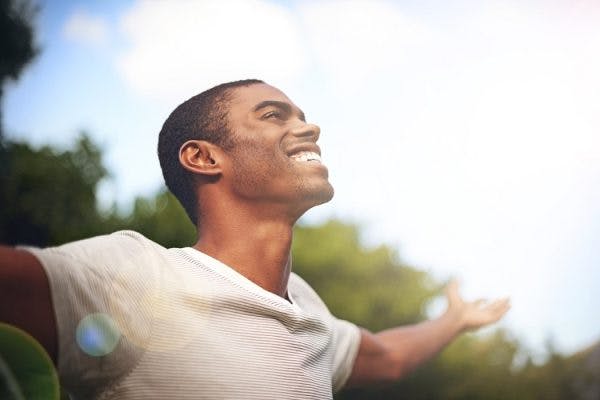 man extending arms in gratitude after overcoming brain injury and depression