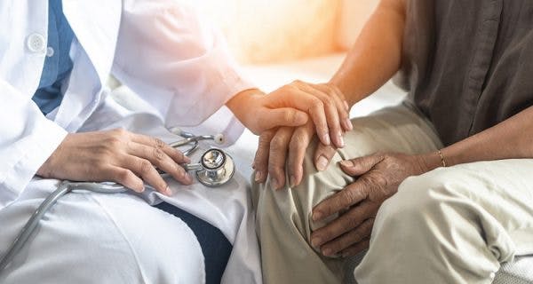 man speaking to a doctor about the complications of traumatic brain injury he's experiencing