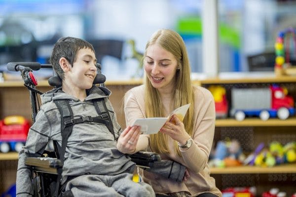 teacher helping student with traumatic brain injury in the classroom