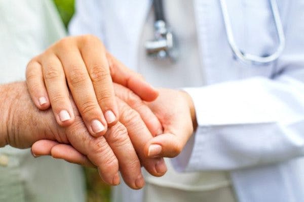 doctor examining a survivor's hands to confirm post-traumatic tremors