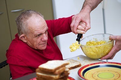 Un patient réapprend à manger : une tâche qui implique les muscles oraux, traités par un orthophoniste, et l'utilisation de ustensiles, traitée à la fois par les physiothérapeutes et ergothérapeutes.