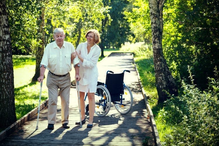 Un survivant d'AVC remarche avec l'aide de sa femme, en symbolisant le thème de cet article : quelles sont les chances de guérir une paralysie après un AVC.