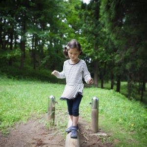 young girl with ataxic cerebral palsy practicing balance exercises outside