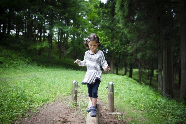 young girl with ataxic cerebral palsy practicing balance exercises outside