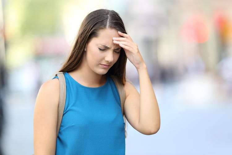 Woman putting hand on forehead because she has dizziness after head injury