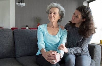 Une femme réconforte sa mère qui a l'air détachée, ce qui symbolise la thème de cette section : les symptômes invisible subis par les patients atteints d'AVC.