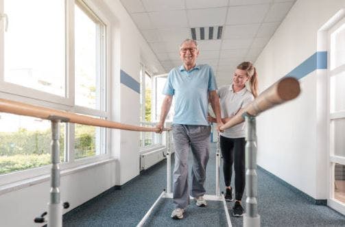 Une thérapeute aide son patient à remarcher pendant une séance de la thérapie hospitalière : qui est la forme de thérapie la plus efficace dont on doit profite pleinement si l'occasion arrive.