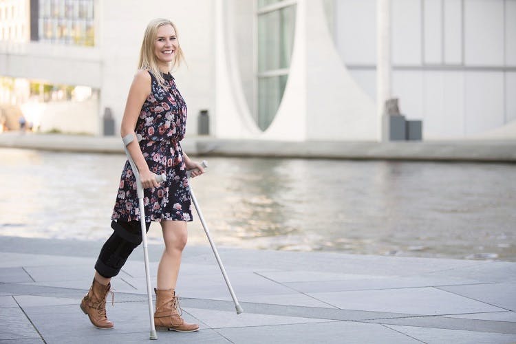 woman with cerebral palsy in the legs walking with crutches