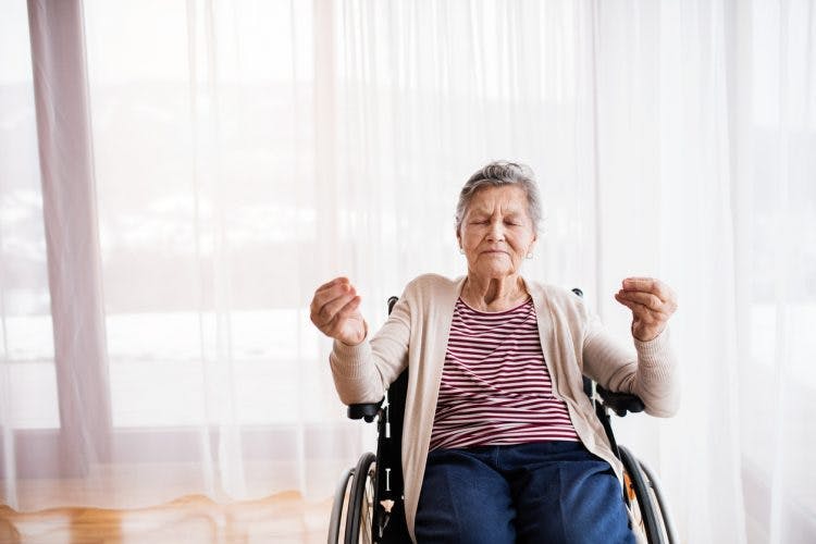 woman practicing yoga for spinal cord injury patients in wheelchair