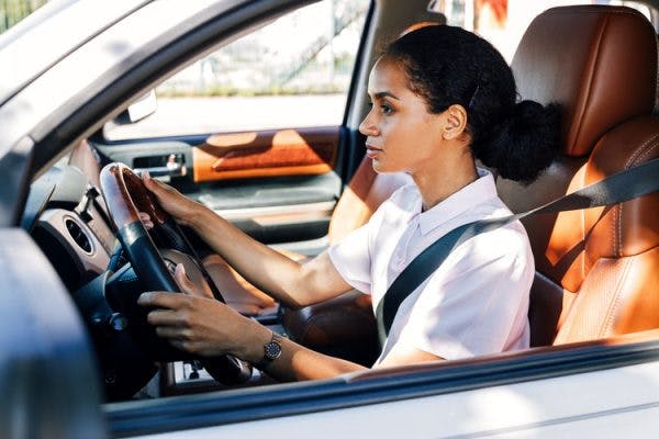capable brain injury survivor sitting behind the wheel about to take a driving test